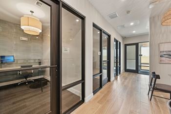 A modern office space with glass walls and wooden floors.